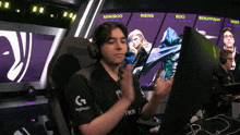a man wearing headphones sitting in front of a screen that says miniboo on it