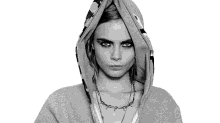 a black and white photo of a woman wearing a hoodie and a necklace .