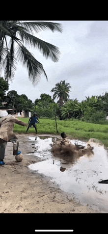a group of people playing soccer in a muddy puddle