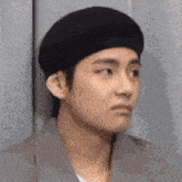 a close up of a person wearing a black beret making a funny face .