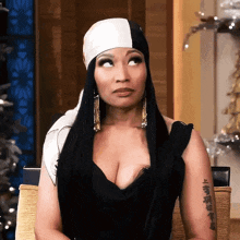 a woman wearing a black and white head scarf looks up