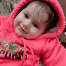 a baby wearing a pink hoodie with a teddy bear that says toy on it