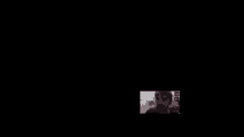 a man is taking a picture of himself on a black background .