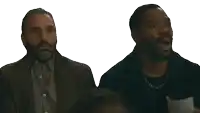 two men are sitting next to each other with one covering his mouth