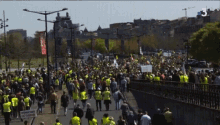 a large crowd of people walking down a street with the number 3 on the bottom