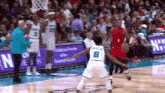 a basketball player with the number 8 on his back is playing defense