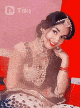 a woman is smiling in front of a red wall that says tiki on it