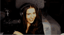 a woman wearing headphones is covering her mouth with her hand