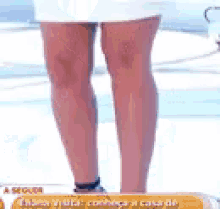 a woman 's legs are shown in a white skirt