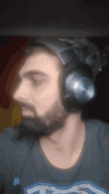 a man with a beard wearing headphones and a t-shirt that says ' a ' on it