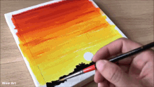 a person is painting a sunset on a piece of canvas