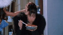 a woman is eating spaghetti with a fork from a bowl .