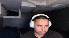 a man wearing headphones is looking at the camera .