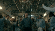 a group of men are standing in a circle with their arms in the air