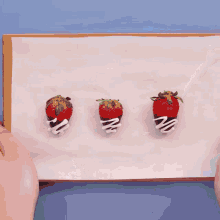 three chocolate covered strawberries on a piece of paper