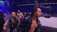 a couple of men are standing in a wrestling ring that says all elite wrestling