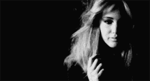 a black and white photo of a woman 's face in the dark .
