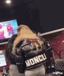 a woman wearing a black jacket that says moncle on the back