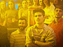 a man with his arms crossed stands in a crowd of people