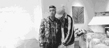 a couple of men are standing next to each other in a room .