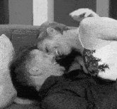 a man and a woman are laying on a couch kissing .