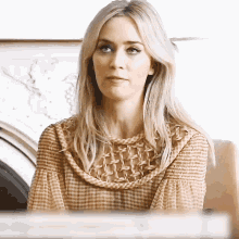 a woman in a plaid shirt is sitting in a chair