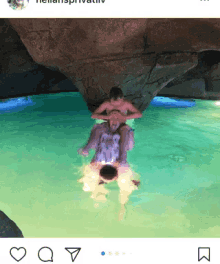 a woman is sitting on a man 's shoulders in the water