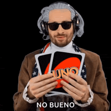 a man wearing headphones and sunglasses is holding a card that says uno