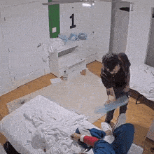 a man is standing next to a woman laying on a bed in a room .