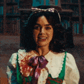 a woman in a green and white dress with a purple bow on her head