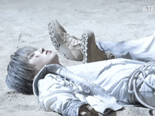 a person laying on a sandy surface with the word te on the bottom