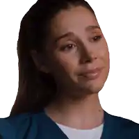 a woman wearing a blue scrub top looks sad