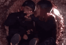 a man and a woman are kissing in a dark tunnel .
