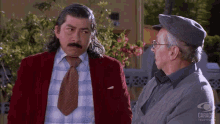 two men are standing next to each other in front of a sign that says " caracol television "