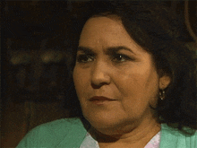 a close up of a woman wearing a green jacket