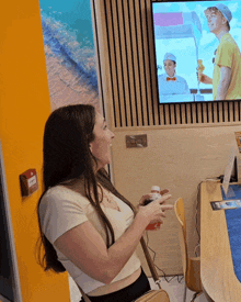 a woman stands in front of a tv with a man holding an ice cream cone