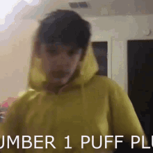 a boy wearing a yellow hoodie with the words number 1 puff puff written below him