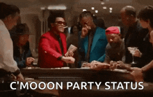 a group of men are standing around a table with a man in a red suit holding money .