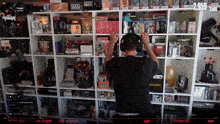 a man is standing in front of a shelf full of video games and toys