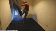 a man in a red sweater is kicking a blue carpet in a room with streamlabs.com written on the bottom