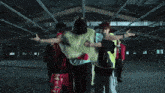 a group of people are standing in a dark room with their arms outstretched