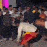 a blurry picture of a group of people including a man in a white shirt and red shorts