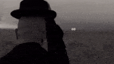 a bald man wearing a hat is looking at something in the distance .