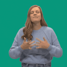 a woman in a blue sweater is making a funny face with her mouth open