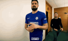 a man wearing a blue shirt that says heitse on it
