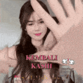 a woman making a stop sign with her hand and the words " kembali kasih " on the bottom