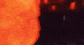 a man in a suit is standing in front of a large orange fireball in a dark room .