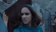 a woman in a blue scarf is being held by a man in a blue jacket .