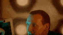 a man is looking at a computer screen with a blue light behind him