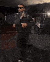 a man in a suit is standing on a red carpet in front of a stan sign
